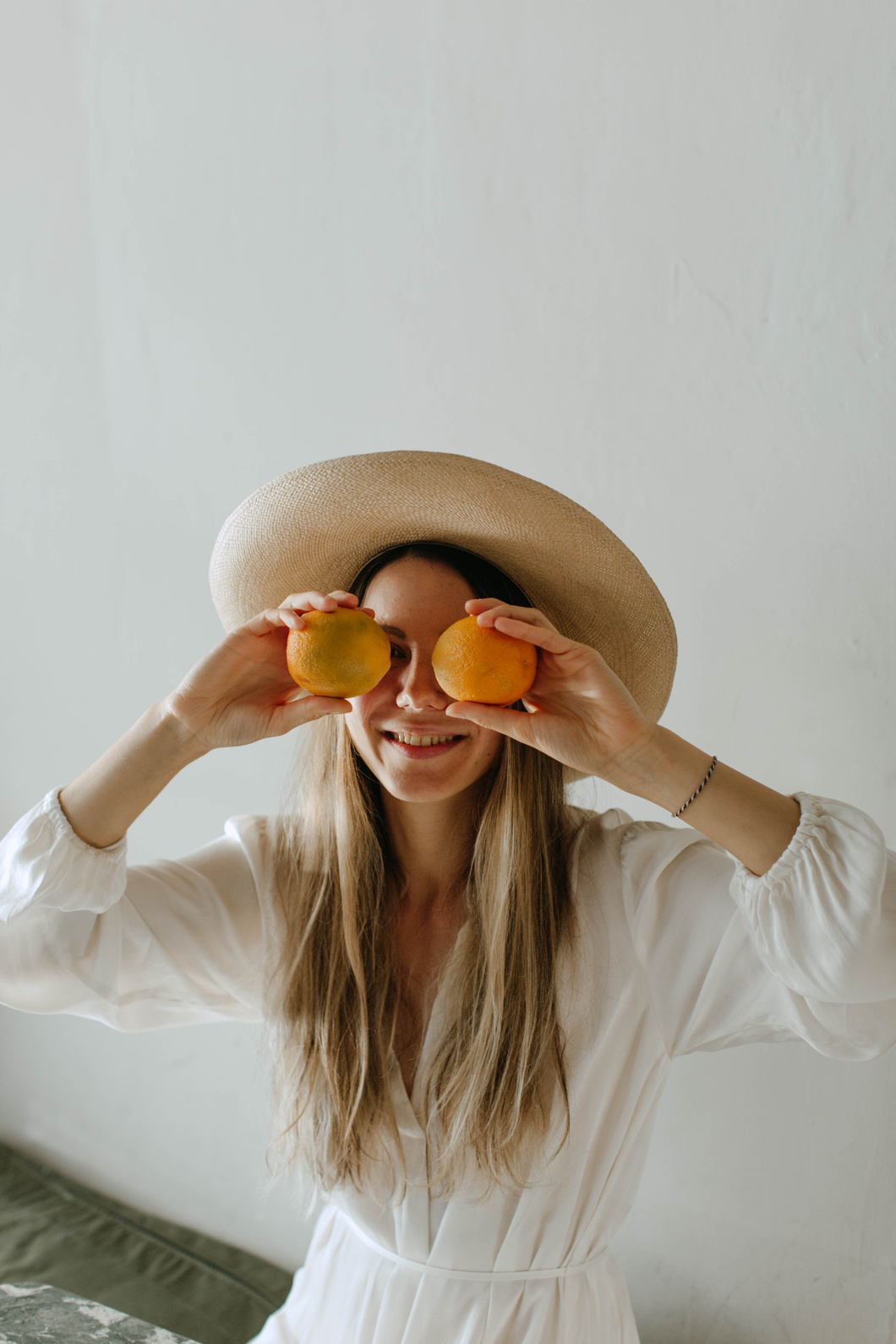 Woman in Off-white Dress and Brown Dress Covering Eyes with Two Oranges