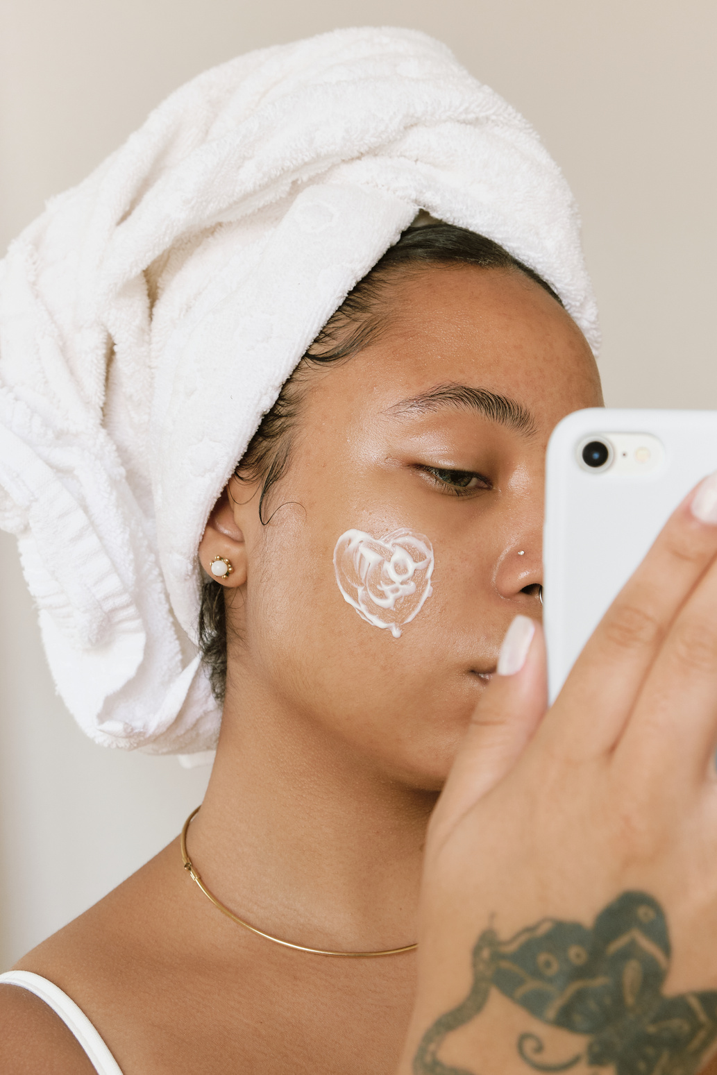 Woman with Facial Cream on Cheek Taking Selfie